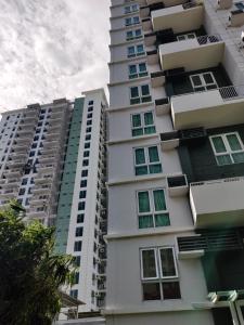 a tall white apartment building with green windows at Abreeza Condo T2-2820 in Davao City