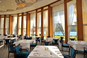 a restaurant with white tables and chairs and windows at The Prince Hakone Lake Ashinoko in Hakone