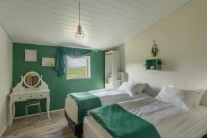 two beds in a room with green walls at Arnarnes Paradise in Arnarnes