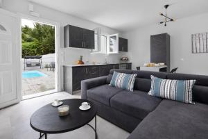 een woonkamer met een bank en een tafel bij Summer Stories Pool Villa in Potamós