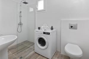 a white bathroom with a washing machine and a toilet at Summer Stories Pool Villa in Potamós