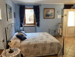 Un dormitorio con una cama con paredes azules y una ventana en Casa Serendipity, en Vercana
