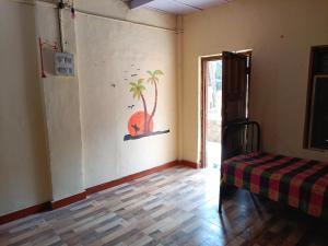 Parvati Niwas Homestay -5 Mins walking frm Revdanda Beach & Fort -Free Wifi في آليباغ: غرفة بها سرير وشجرة نخيل على الحائط +17 صورة