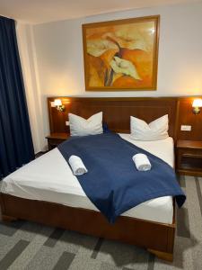 a bedroom with a large bed with a blue blanket at Pensiunea View in Cluj-Napoca