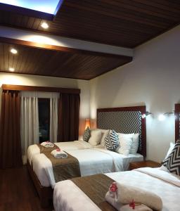 Habitación de hotel con 2 camas y sofá en Kencana Garden, en Nusa Lembongan