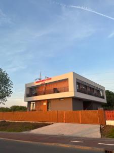 un bâtiment avec une clôture orange devant lui dans l'établissement Pensiunea View, à Cluj-Napoca