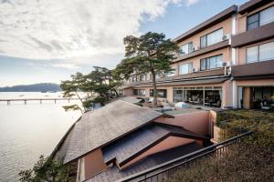 una vista esterna di un edificio accanto a un corpo idrico di Komatsu-kan Kofu-tei a Matsushima