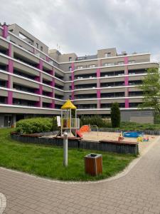 um grande edifício com um parque infantil em frente em Dyrekcyjna Apartment em Breslávia