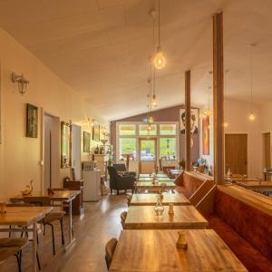 un restaurante con mesas de madera y sillas en una habitación en Arnarnes Paradise, en Arnarnes