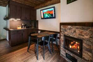 a kitchen with a fireplace and a table and chairs at Novosiele Residence - nad górską rzeką - Leśne Spa sauna jacuzzi - Bieszczady in Bystre