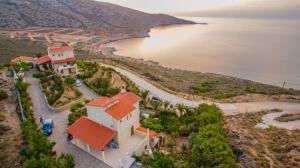 an aerial view of a house next to the water at Vitamin Sea Panoramic Villas in Agia Pelagia