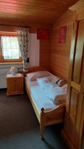 a bedroom with a bed in a wooden room at Gasthaus Montafonerhüsli in Sankt Gallenkirch