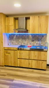 a kitchen with wooden cabinets and a blue counter top at Acogedor y moderno Glamping en container, 10 min del centro in Chiquinquirá