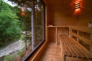 a porch of a wooden cabin with a bench and a window at Novosiele Residence - nad górską rzeką - Leśne Spa sauna jacuzzi - Bieszczady in Bystre
