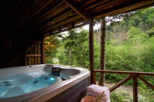 a large bath tub in a room with a window at Novosiele Residence - nad górską rzeką - Leśne Spa sauna jacuzzi - Bieszczady in Bystre
