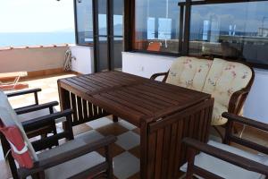 a wooden table and chairs on a balcony at Big Dino's Galini in Nea Vrasna