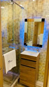 a bathroom with a sink and a shower with a mirror at Acogedor y moderno Glamping en container, 10 min del centro in Chiquinquirá