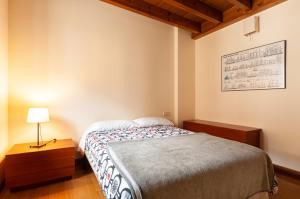 a small bedroom with a bed and a lamp at Vivienda Vacacional Leo in Andrín