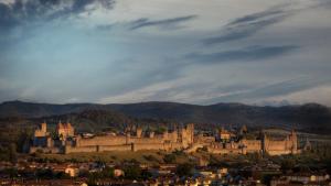 a large castle on a hill with a city at L'Atelier B&B - Esprit bohème, la nature en ville in Carcassonne