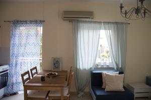 a dining room with a table and a blue couch at Blue Theros Apartments in Paralia Dionysiou
