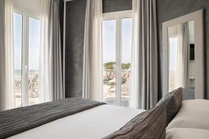 a bedroom with a bed and a view of the ocean at Hotel Sayonara in Lido di Jesolo +77 photos