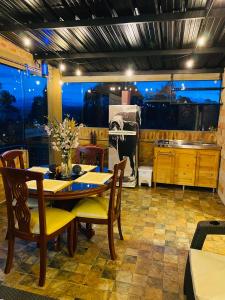 Romántica Cabaña con vista a la ciudad, 10 min del Centro في Chiquinquirá: غرفة طعام مع طاولة وكراسي ومطبخ
