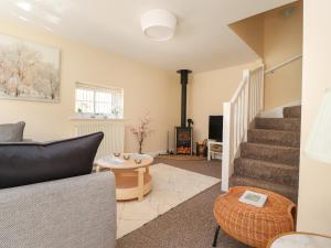 a living room with stairs and a couch and a tv at Swallows Barn at Yew Tree Farm in Preston