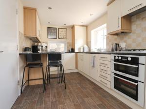 uma cozinha com armários brancos e electrodomésticos pretos em Swallows Barn at Yew Tree Farm em Preston