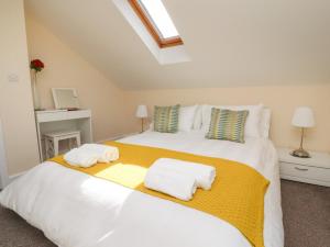 1 dormitorio con 1 cama blanca grande y toallas. en Swallows Barn at Yew Tree Farm, en Preston