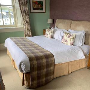 a bedroom with a large bed with white sheets and pillows at Port Charlotte Hotel in Port Charlotte
