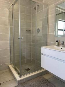 una doccia con una porta in vetro in un bagno di Waterfall Two-Bedroom Apartment a Midrand