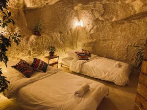 a room with two beds in a cave at 7 Caves Hotel in Al Jāyah