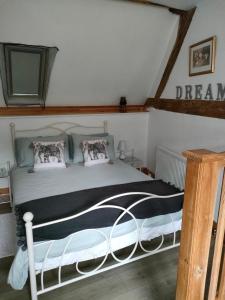 a bedroom with a bed with a black and white comforter at Les Petits Champs in Buais