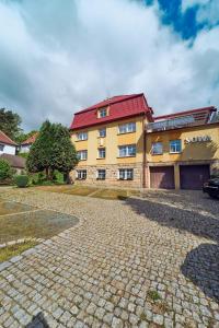 a large yellow building with a red roof at Marel-Apartments U SOWY- Park- Polanica Zdrój in Polanica-Zdrój