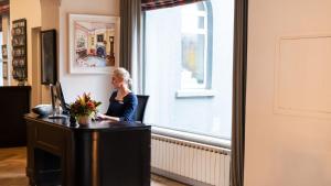 una mujer sentada en un escritorio frente a una ventana en The Montenotte Hotel, en Cork