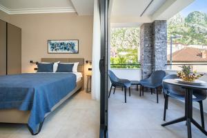 1 dormitorio con 1 cama, mesa y sillas en C Group apartments en Kotor