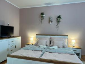 A bed or beds in a room at Négy Évszak Vendégház