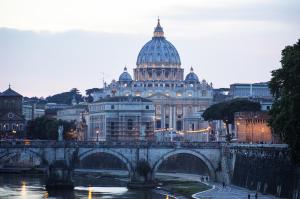 eine Brücke über einen Fluss vor einem Gebäude in der Unterkunft Roma Vatican in Rom