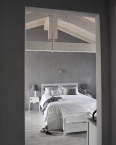 1 dormitorio con cama blanca y marco de cama blanco en Il Sassoscritto Bed and Breakfast, en Montecalvo Versiggia