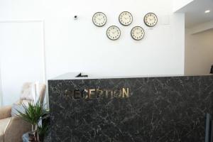 ein Empfangsschild in einem Zimmer mit Uhren an der Wand in der Unterkunft Kıvanç Residence in Trabzon