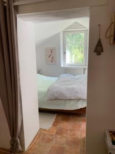 1 dormitorio con cama y ventana en le hameau de Sylvanes, en Sylvanès