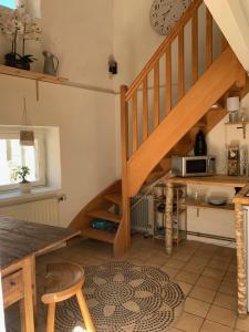 a kitchen with a wooden staircase and a table at le hameau de Sylvanes in Sylvanès