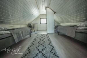 a attic room with two beds and a rug at Aava Sky Village in Aavasaksa