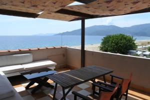 een balkon met een tafel en stoelen en de oceaan bij Big Dino's Galini in Nea Vrasna