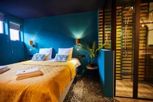 um quarto com uma cama grande e paredes azuis em Boutique Hotel de Drentse Liefde em Dwingeloo