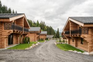 una carretera frente a dos casas de troncos en Clofers Leisure Lodges Jenig, en Jenig