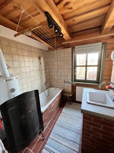 a bathroom with a tub and a sink and a bath tub at Őrségi Mi Kis Házunk vendégház in Szalafő