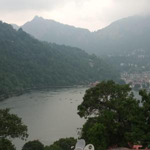 Blick auf einen Fluss mit Bäumen und Bergen in der Unterkunft Lakshmi Kutteer Homestay in Nainital