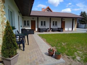 a patio of a house with a table and chairs at Flauta Apartamenty Rodzinne in Mielenko
