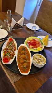 una mesa con tres platos de comida en una bandeja en Hotel Surya Palace, en Chaumu